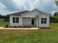 Charming single-story home with light siding, a black door, and a well-manicured lawn at 90 Brookhaven Dr, Spring Hope, NC 27882
