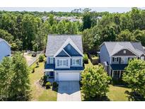 Charming two-story home with a manicured lawn, beautiful trees, and an attached two-car garage at 1004 Bridlemine Dr, Fuquay Varina, NC 27526