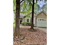 Charming home featuring a bay window and an attached one-car garage with trees at 1017 Red Hat Ln, Durham, NC 27713
