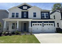 Two-story home featuring blue and white accents, a two-car garage, and manicured landscaping, enhancing its curb appeal at 1029 Bostonian Dr, Knightdale, NC 27545