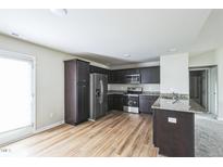 Modern kitchen featuring stainless steel appliances and dark cabinetry with granite countertops at 103 Hampshire Pl, Kenly, NC 27542