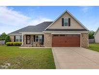 Charming brick home featuring a well-manicured lawn and an inviting two-car garage at 106 Lockwood Dr, Cameron, NC 28326