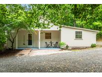 Charming home exterior with covered porch, gravel driveway, and lush landscaping at 1085 Bynum Rd, Pittsboro, NC 27312