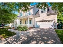 Charming two-story home featuring a welcoming front porch, well-maintained lawn, and attached two-car garage at 116 Hamilton Hedge Pl, Cary, NC 27519