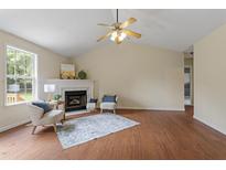 Bright living room featuring a fireplace, ceiling fan, hardwood floors, and two chairs at 118 Setter Pt, Clayton, NC 27520