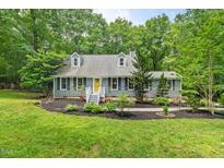 Charming home featuring dormer windows, black shutters and a well manicured lawn at 1205 Elysian Way, Rougemont, NC 27572