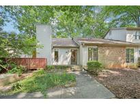 Charming home featuring a brick accent, chimney, and inviting front entrance surrounded by mature trees at 124 Twin Oaks Pl, Cary, NC 27511