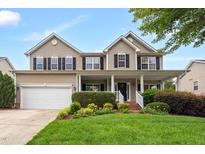 Charming two-story home features a manicured front yard and inviting front porch with classic black shutters and a two car garage at 1428 White Opal Dr, Knightdale, NC 27545
