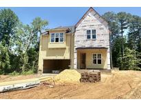 New construction home featuring an attached garage and covered entry, surrounded by a partially landscaped yard at 1701 Burnette Garden Path, Raleigh, NC 27612