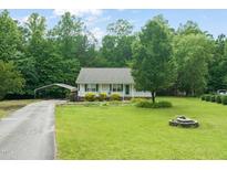 Charming single-story home with a well-maintained lawn, cozy porch, and convenient carport at 215 Virginia Pine Dr, Clayton, NC 27520