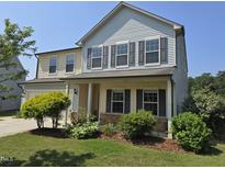 Charming two-story home featuring stone accents, a covered porch, and a well-manicured lawn at 2511 Dalmahoy Ln, Fuquay Varina, NC 27526