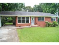 Charming brick home featuring a cozy front porch and a convenient covered carport, all set on a lush green lawn at 2626 Crestline Ave, Raleigh, NC 27603