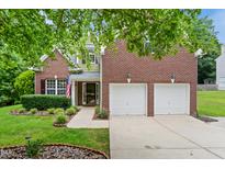 Two-story brick home with a two-car garage, manicured lawn and an American flag at 2801 Margots, Wake Forest, NC 27587