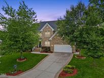Beautiful brick home with a well-manicured lawn and a long driveway leading to an attached two-car garage at 4 Pickard Pl, Durham, NC 27703