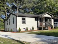 Charming renovated home with a concrete driveway, landscaped yard, and a welcoming front porch at 401 Commonwealth St, Durham, NC 27703