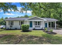 Charming single-story home featuring a white brick exterior, teal door, and a well-maintained front yard at 460 Bunn Elementary School Rd, Bunn, NC 27508