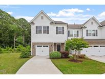 Charming two-story townhome featuring a stone accents, a single-car garage, and a well-manicured lawn at 520 Kenton Mill Ct, Rolesville, NC 27571