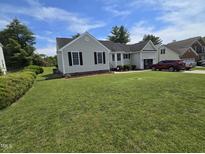 Charming single-story home with a well-manicured lawn and black shutters against a light gray exterior at 5810 Stardust Ct, Durham, NC 27712