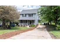 Charming two-story home featuring a welcoming front porch and well-maintained landscaping at 601 Country Ln, Holly Springs, NC 27540