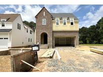 New two-story home with brick and siding, featuring an attached garage and unfinished landscaping at 6505 Burnette Flower Way, Raleigh, NC 27612