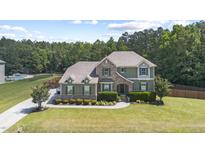 Beautiful two-story home with a stone and green facade and mature landscaping at 6521 Sunset Manor Dr, Wake Forest, NC 27587