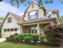 Charming two-story home with brick and siding, complemented by lush landscaping and a covered front porch at 7768 Berry Crest Ave, Raleigh, NC 27617