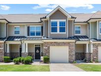 Charming townhome featuring stone accents, a one-car garage, and a welcoming front entrance at 7807 Elmshire Way, Raleigh, NC 27616
