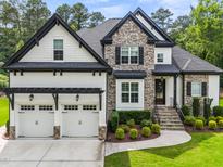 Beautiful two-story home featuring stone accents, a three-car garage, and professionally landscaped front yard at 9713 San Remo Pl, Wake Forest, NC 27587