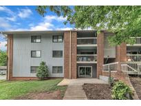 Brick apartment building featuring upper level balconies and grey siding at 1008 Sandlin Pl # J, Raleigh, NC 27606