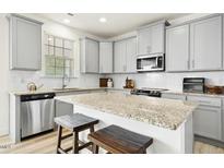 Bright kitchen with light grey cabinets, granite countertops, and stainless steel appliances at 116 Hayfield Dr, Lillington, NC 27546