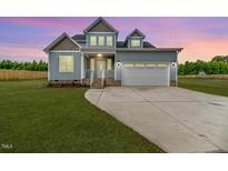 Charming two-story home featuring blue siding, a two-car garage, and a well-manicured lawn at 117 Knight Rd Rd, Broadway, NC 27505