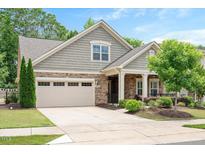 Charming home featuring a stone and shake facade, well-manicured lawn, and a two-car garage at 125 Greenway Landing Lndg, Chapel Hill, NC 27516