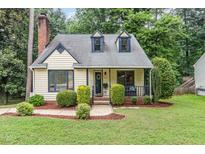 Charming exterior of a two-story home featuring dormer windows and manicured landscaping at 1426 Cedar Branch Ct, Wake Forest, NC 27587