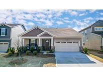 Charming single-Gathering home featuring a two-car garage, covered porch, and tasteful stone accents at 148 Vaughan Farms Drive Dr, Angier, NC 27501