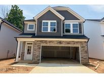 Charming new two-story home with a gray exterior, stone accents, and an attached two-car garage at 285 Gregory Village Dr, Lillington, NC 27546