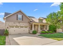 Charming two-story home with a manicured lawn, front porch, and attached two-car garage at 4110 Argyle Trl, Burlington, NC 27215