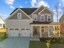 Charming two-story home featuring a covered porch, two-car garage, and beautifully landscaped front yard at 432 Golden Dragonfly St, Wake Forest, NC 27587