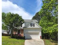 Charming two-story home with a well-maintained lawn, flowering bushes, and an attached two-car garage at 4903 Bridgewood Dr, Durham, NC 27713