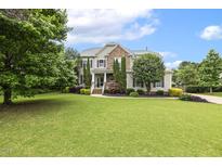 Charming two-story home with stone accents, mature trees, and a sprawling green lawn at 5516 Colonial Oaks Dr, Apex, NC 27539