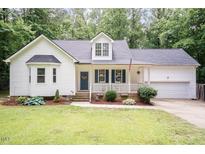 Charming home with a welcoming front porch, blue shutters, and a well-maintained lawn surrounded by lush greenery at 589 John Mitchell Rd, Youngsville, NC 27596