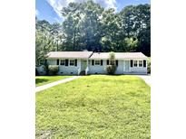 Charming one-story home with a beautiful lawn, walkway, and lovely curb appeal at 808 Ravenwood Dr, Raleigh, NC 27606