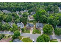 A beautiful aerial view of a suburban neighborhood featuring lush green trees and well-maintained homes at 8913 Walking Stick Trl, Raleigh, NC 27615