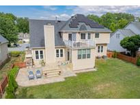 Well-maintained, two-story home featuring a stone patio and second floor balcony with solar panels in a private backyard at 8913 Walking Stick Trl, Raleigh, NC 27615