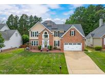 Traditional two-story home featuring a brick and siding exterior, well-manicured lawn, and two-car garage at 8913 Walking Stick Trl, Raleigh, NC 27615