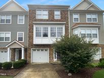 Charming multi-level townhouse with stone accents, attached garage, and well-maintained landscaping at 102 Darley Dale Loop, Apex, NC 27502