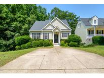 Well-maintained single-Gathering home with mature landscaping, a driveway, and black front door at 106 Gumdrop Path, Apex, NC 27502