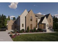 Stunning new construction home featuring a stone and wood facade, professional landscaping, and a three-car garage at 1132 Wimbleton Dr, Raleigh, NC 27609