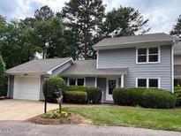 Charming gray home features a well-manicured lawn, inviting entrance, and attached one car garage at 1600 Budwood Dr, Raleigh, NC 27609