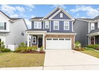 Charming two-story home showcasing navy siding, brick accents, and a spacious driveway at 1725 Winter Jasmine Ln, Wake Forest, NC 27587