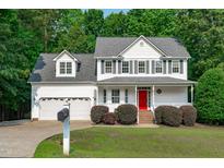 Charming two-story home with a bright red front door, well-manicured lawn and lush landscaping at 188 Worthington Ct, Clayton, NC 27527